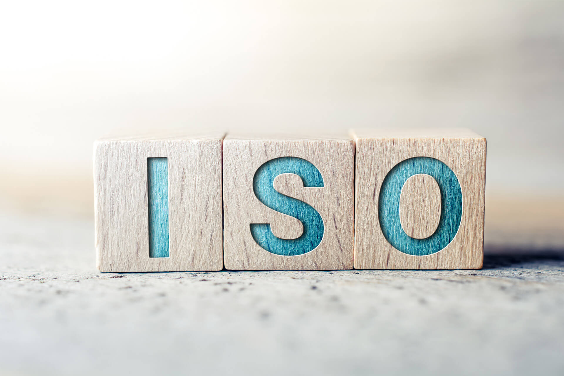 DIN ISO 30415 Drei Holzwürfel mit den Buchstaben ISO.