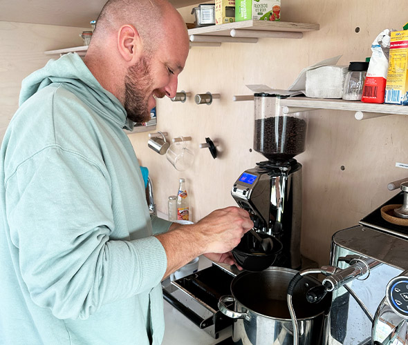 Julien beim Maultaschen-Mittwoch Ein Mann mit einem mintfarbenen Pullover füllt eine Maultaschensuppe in eine Schüssel.