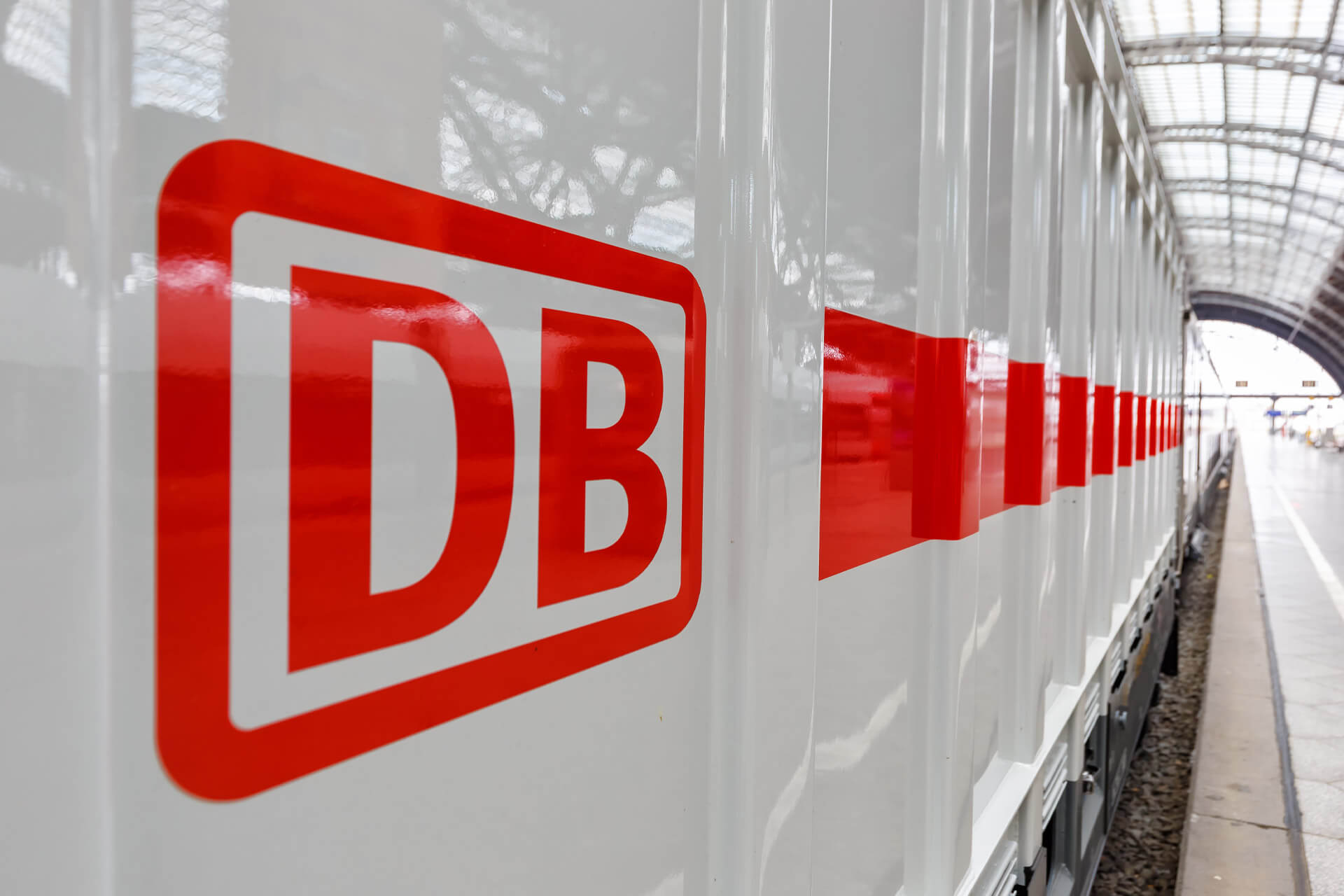Porträt der D&I-Aktivitäten der Deutschen Bahn Das Deutsche Bahn Logo ist in roter Schrift auf einem weißen Zug in einem Bahnhof zu sehen.